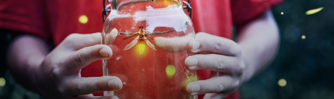 Child holding jar of fireflies