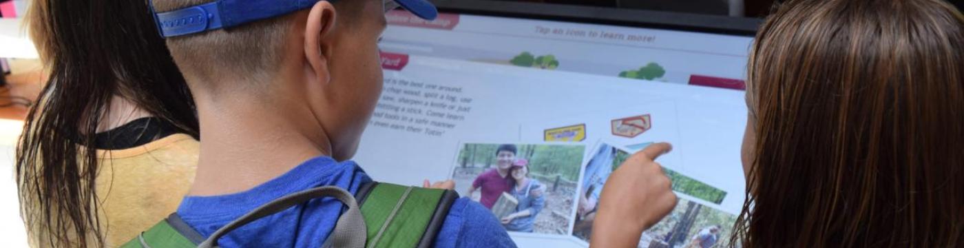 boy using touchscreen kiosk boy using touchscreen kiosk